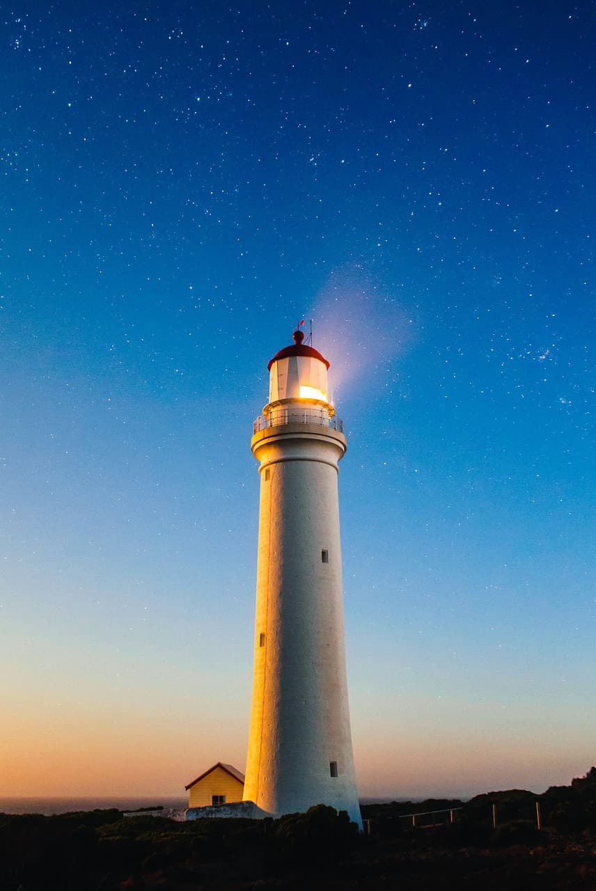 A lighthouse standing tall against a stormy sky, symbolizing guidance and hope in turbulent times.